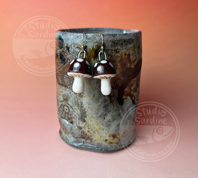 Hand-sculpted porcelain toadstool mushroom earrings in dark brown