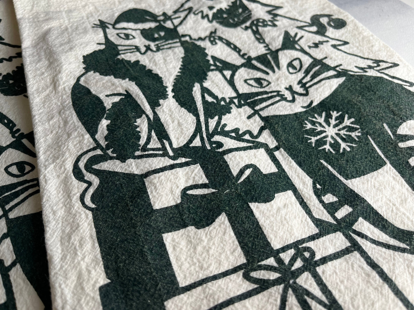 Festive Felines hand-printed tea towel in dark forest green