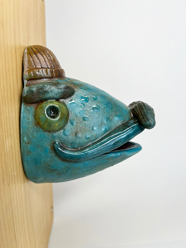 Gus fish-head wall-hanging with tan beanie and mustache