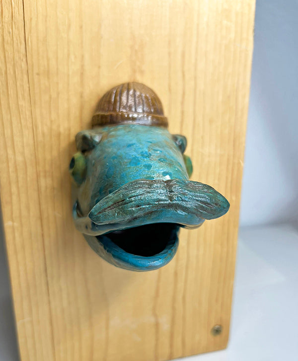 Gus fish-head wall-hanging with tan beanie and mustache