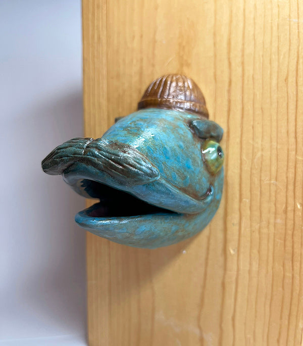 Gus fish-head wall-hanging with tan beanie and mustache