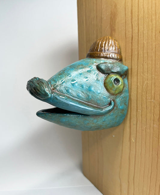 Fish-head wall-hanging with tan beanie and mustache