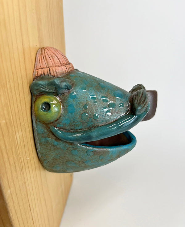 Marty fish-head wall-hanging with peach beanie and pipe