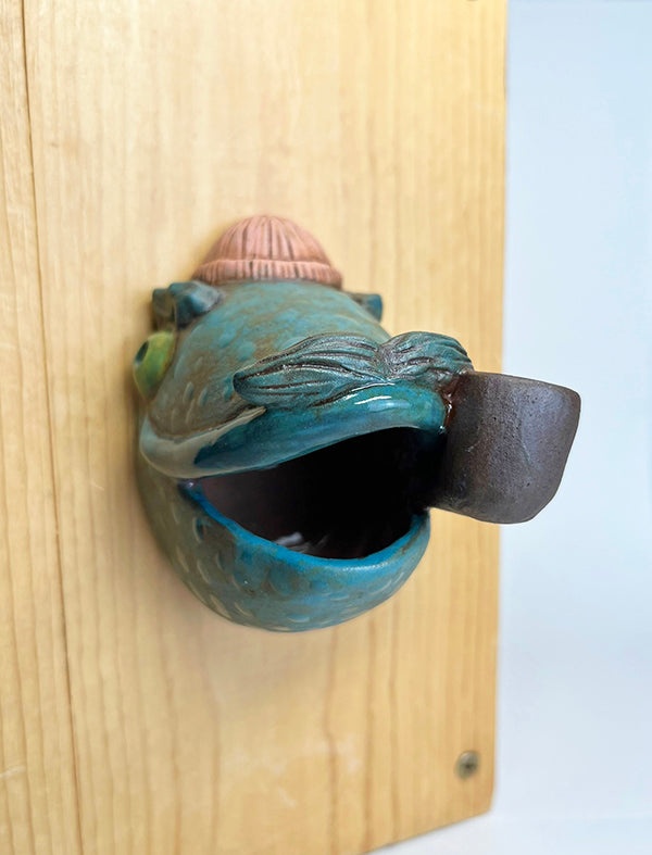 Marty fish-head wall-hanging with peach beanie and pipe