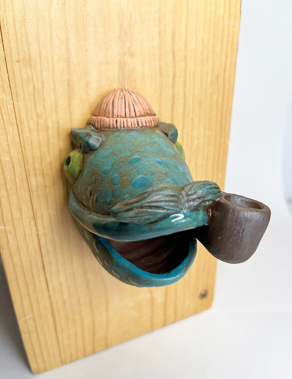 Marty fish-head wall-hanging with peach beanie and pipe