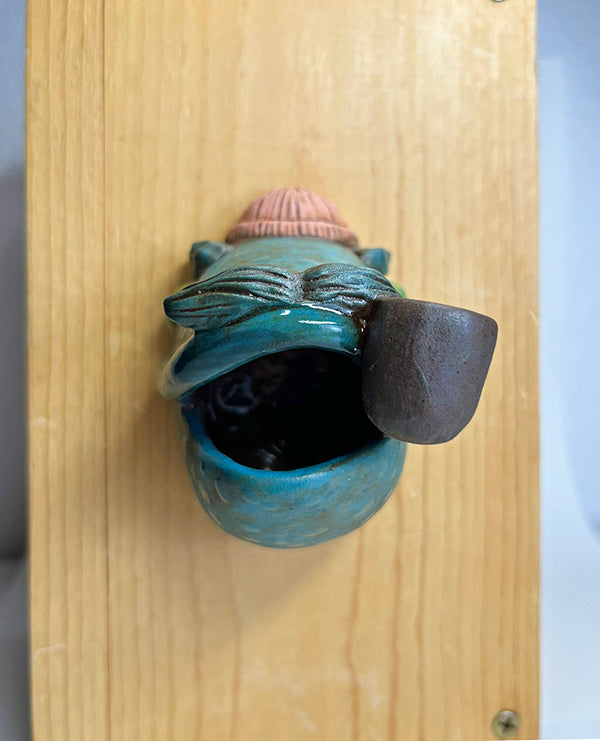 Marty fish-head wall-hanging with peach beanie and pipe