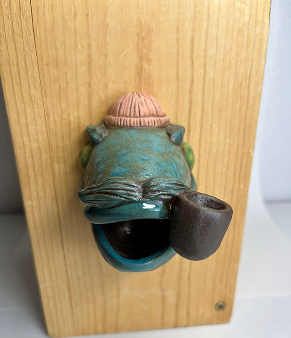 Marty fish-head wall-hanging with peach beanie and pipe
