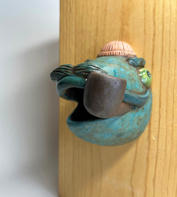 Marty fish-head wall-hanging with peach beanie and pipe
