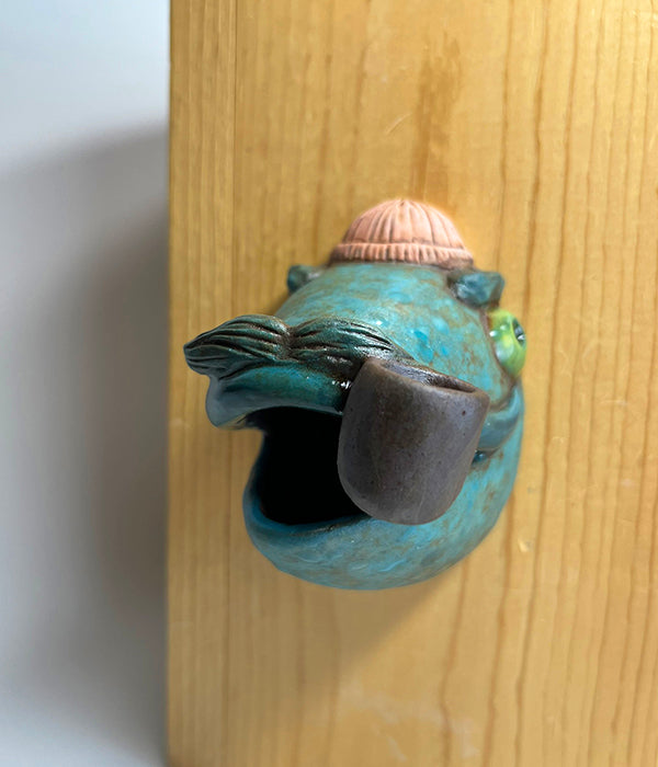 Marty fish-head wall-hanging with peach beanie and pipe