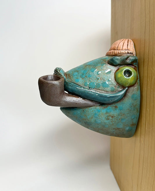Fish-head wall-hanging with peach beanie and pipe
