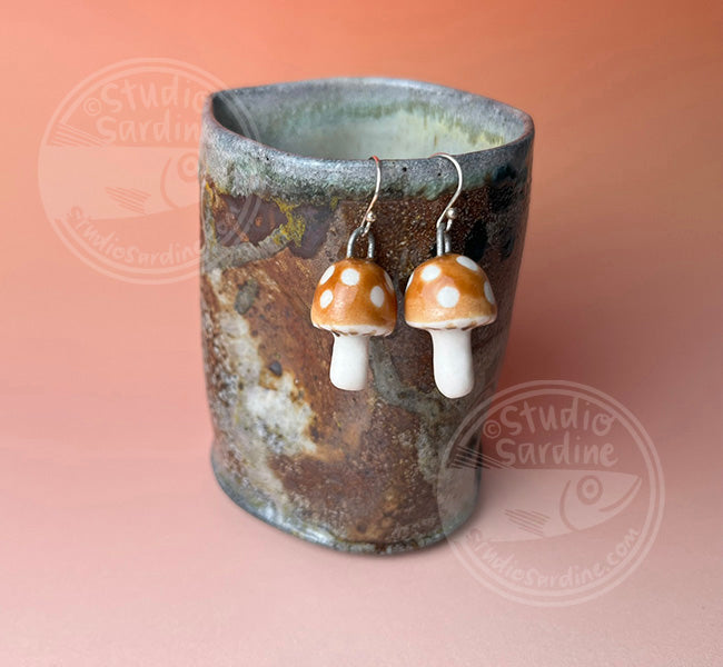 Hand-sculpted porcelain toadstool mushroom earrings in caramel
