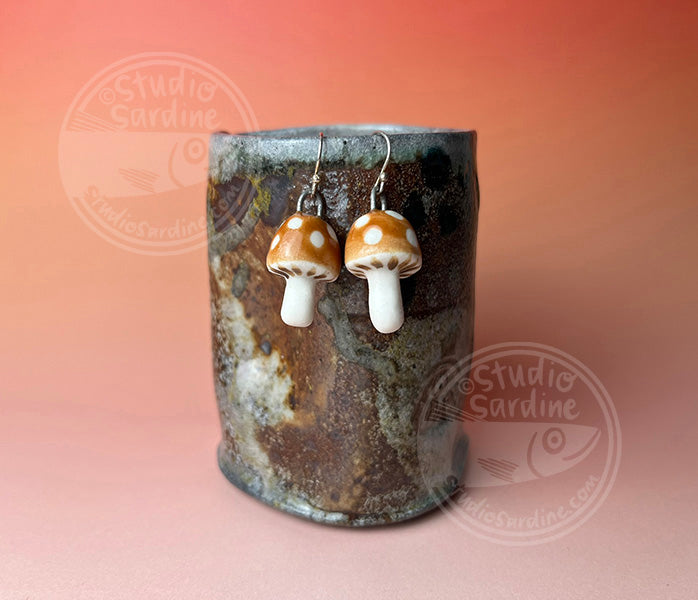 Hand-sculpted porcelain toadstool mushroom earrings in caramel