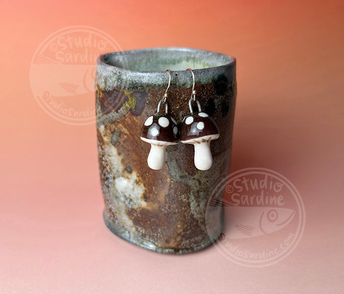 Hand-sculpted porcelain toadstool mushroom earrings in dark brown